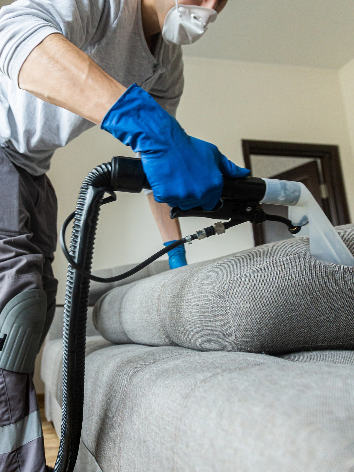 Nettoyage professionnel : Un technicien utilise un appareil de nettoyage pour désinfecter et assainir un canapé, garantissant un intérieur hygiénique et confortable.